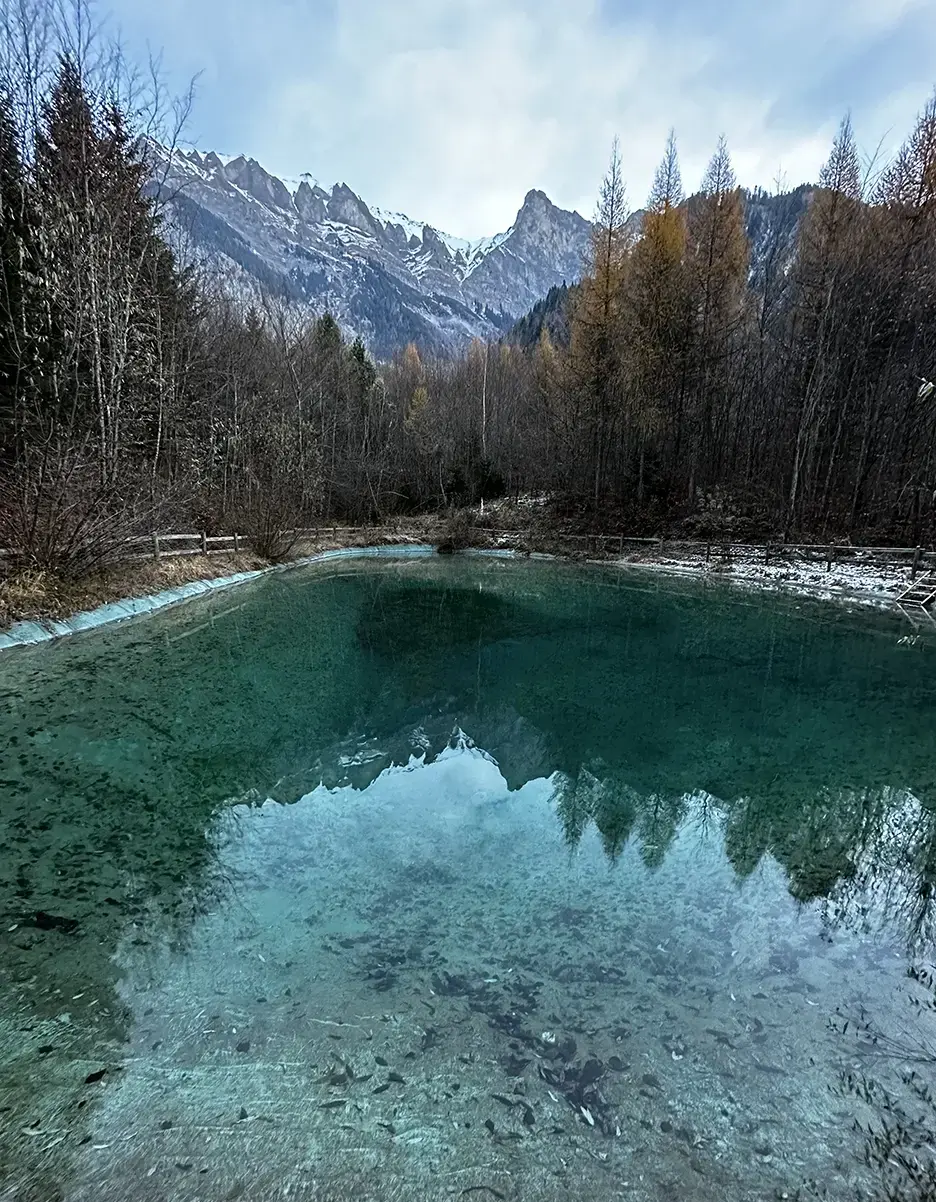 Verschneite Berggipfel spiegeln sich in einem glasklaren Bergsee