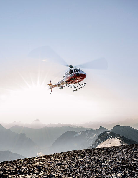 Ein Suchhelikopter der Rega im Einsatz in den Bergen